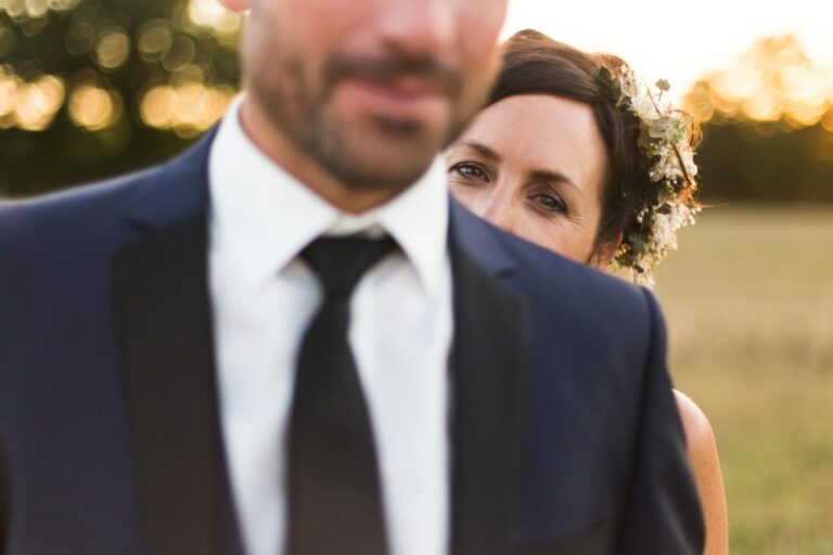 gros plan sur le regard de la marié regardant par dessus l'epaule de son mari flou au premier plan