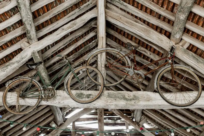 Vieux vélo, accroché sur une poutre sur une toiture dans une grange en bois