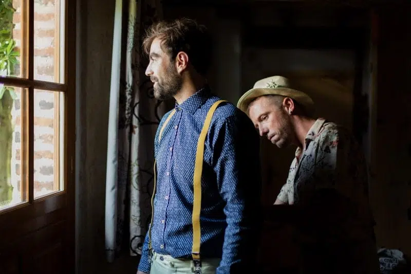 Temoin qui habille le Mariée, qui regarde par la fenêtre