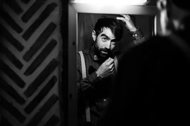 Homme brun et barbu qui se recoiffe devant un miroir Photo, noir et blanc