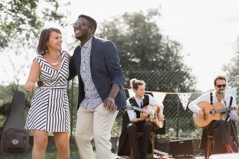 Invité d'un Mariage, qui danse avec un groupe de musiciens derrière eux