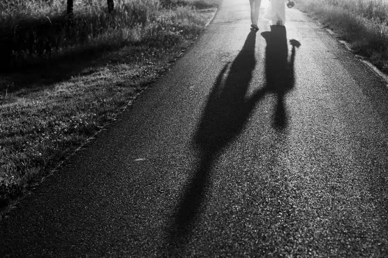 Silhouette des ombres en noir et blanc d'un couple qui marche sur une route