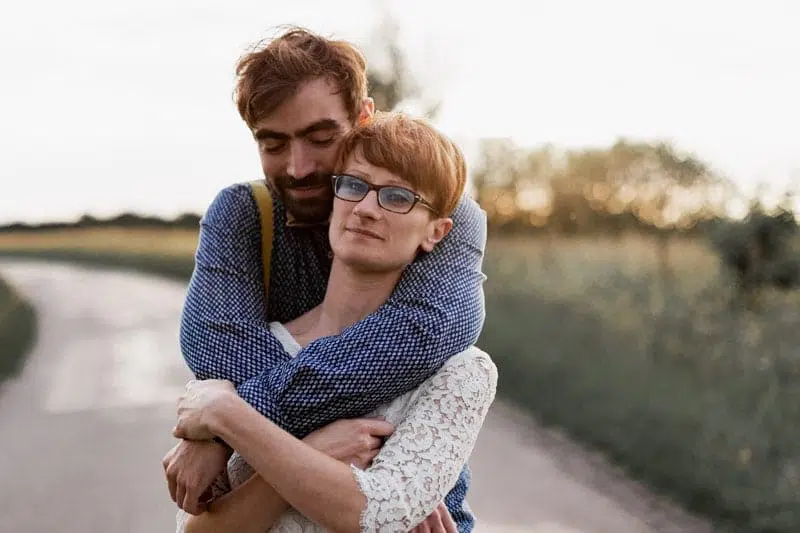 Couple de Mariée, qui s'enlacent sur une petite route au coucher de soleil