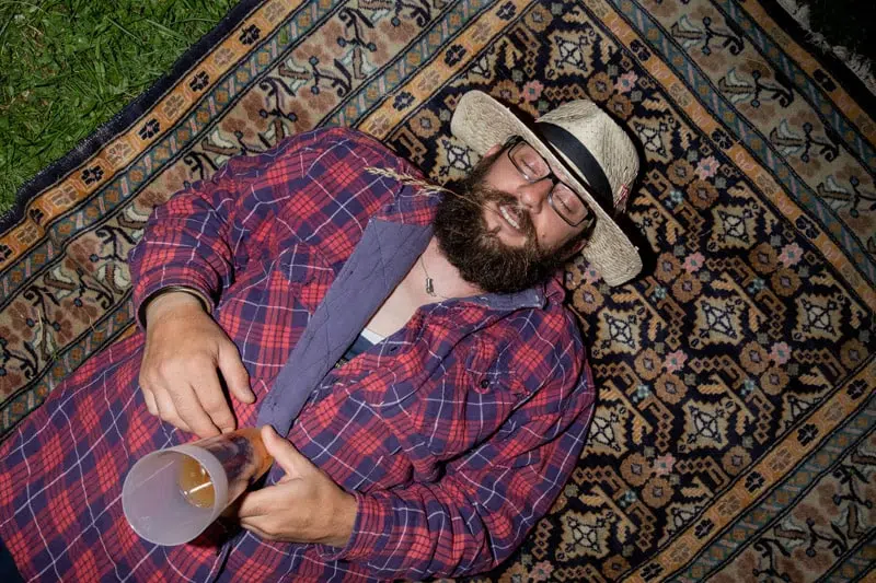 Homme allongé avec un chapeau sur un tapis