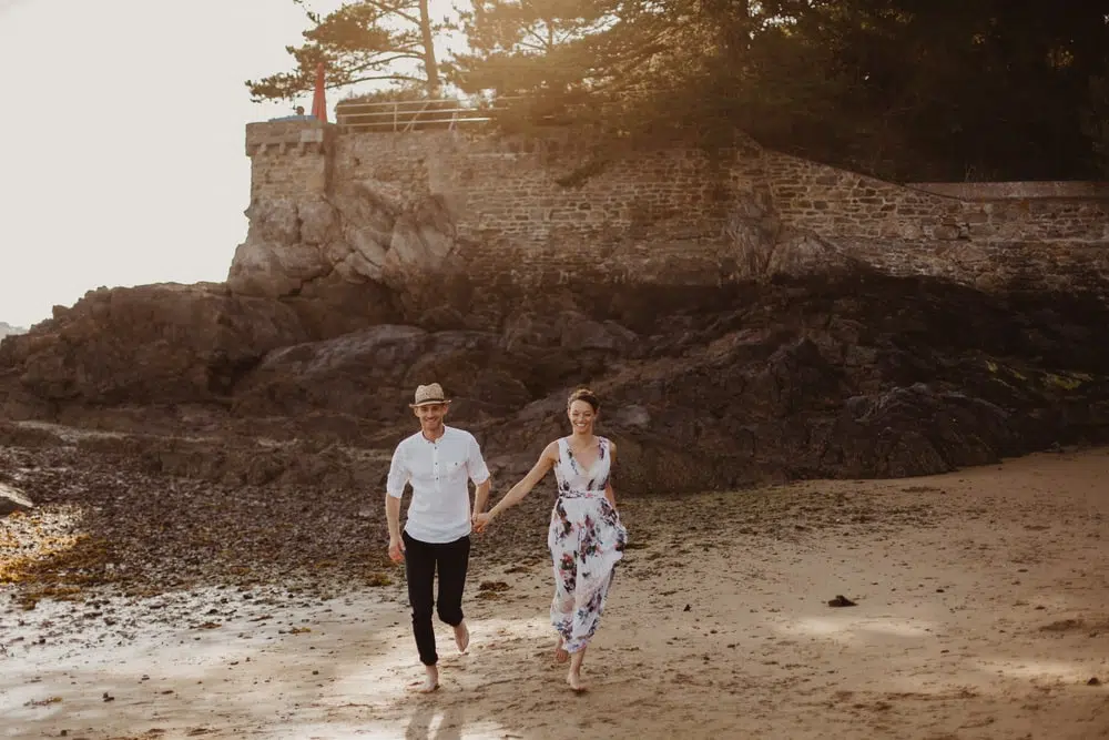 couple se tenant la main dans une crique de saint malo