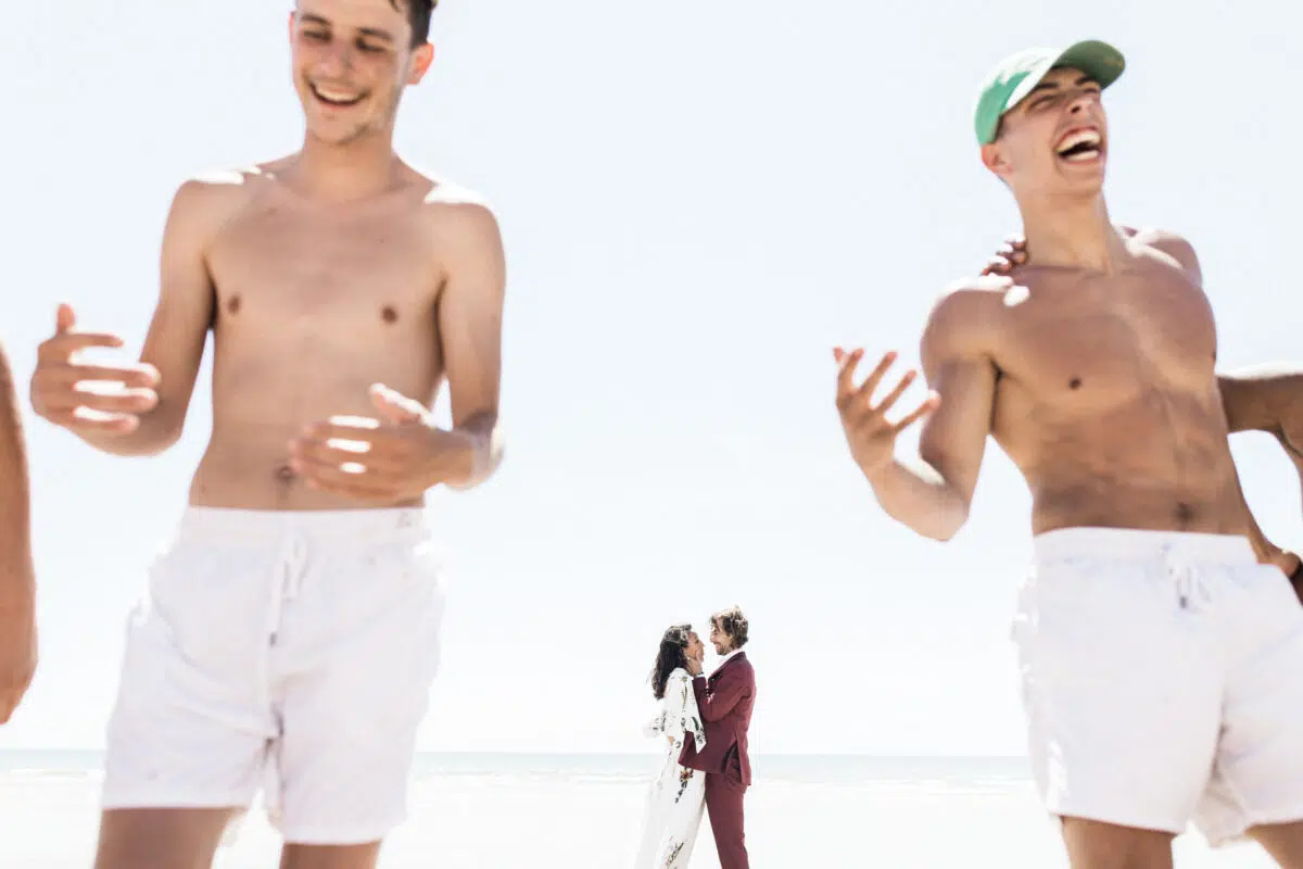 homme torse nue et couple en arrière plan qui s'embrasse