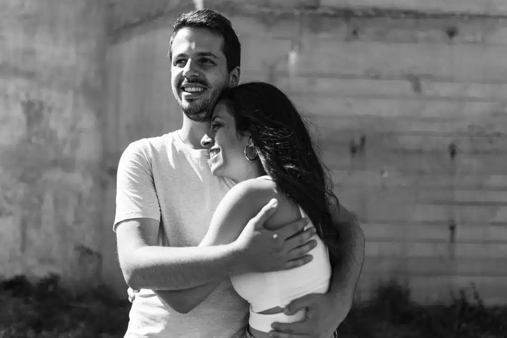 couple qui rit en noir et blanc et s'enlace