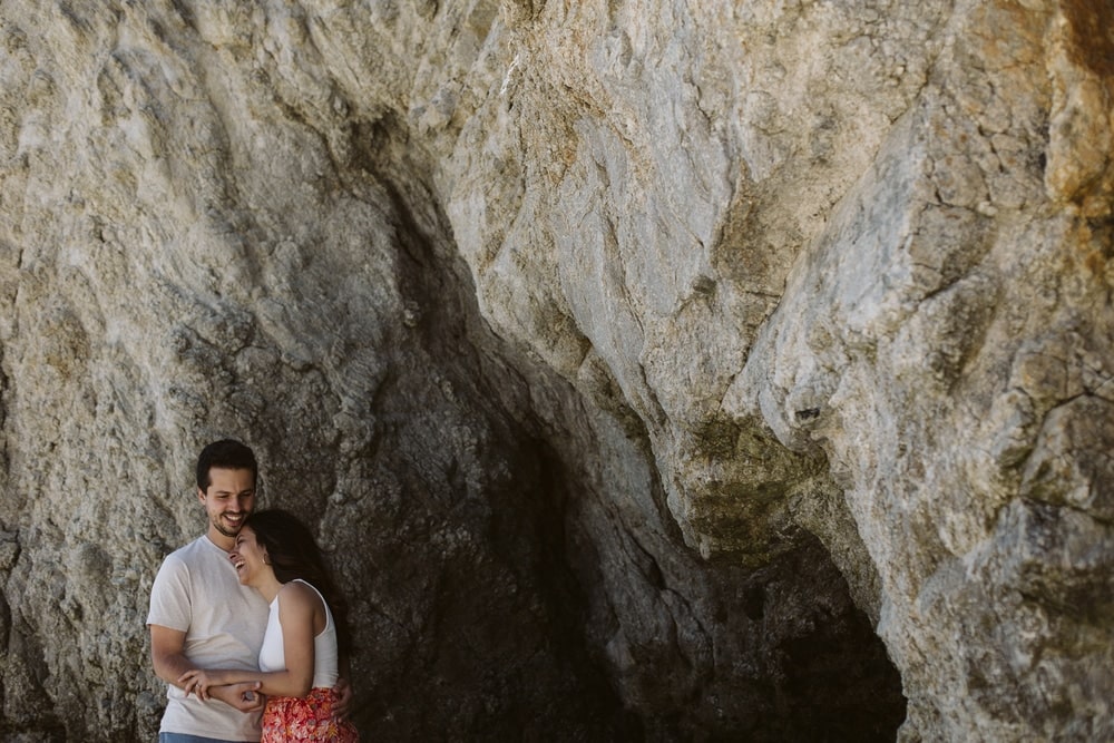 couple posé à coté d'une falaise rocheuse