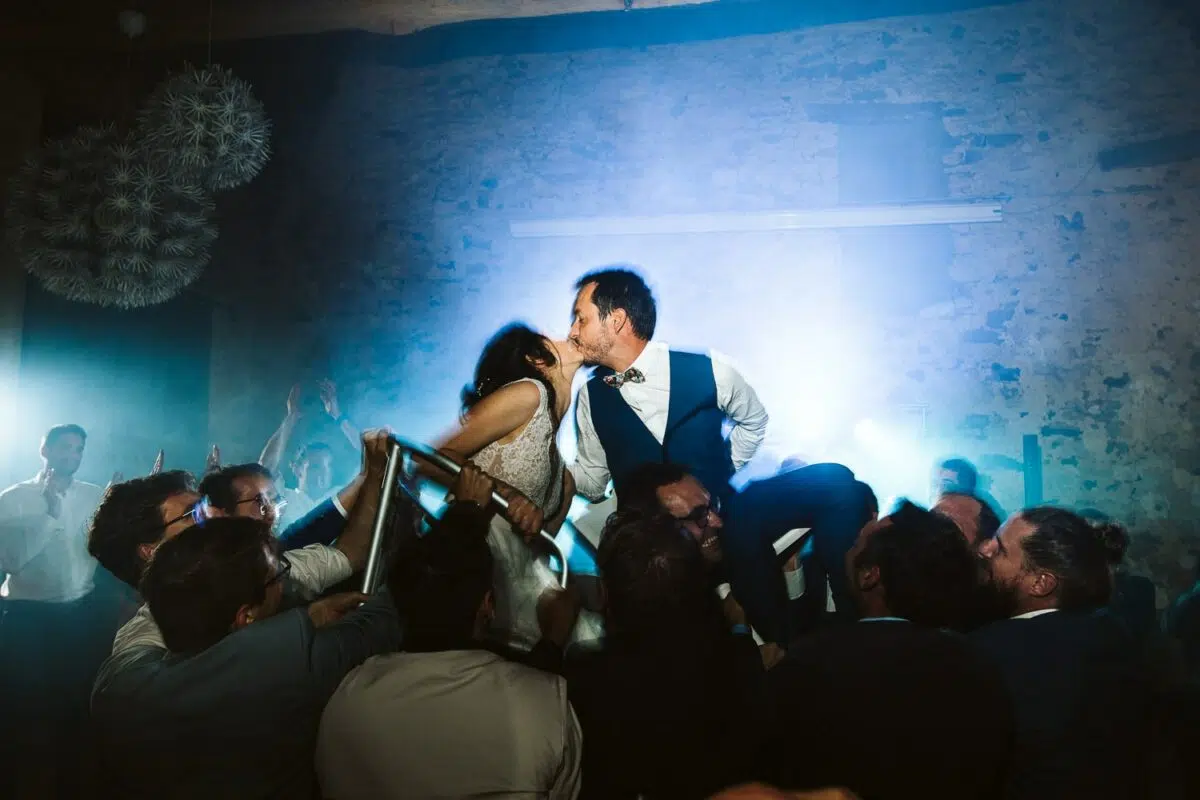 Mariés portés par les invités, baiser en pleine soirée – Ferme de la Bretèche, Genainville.