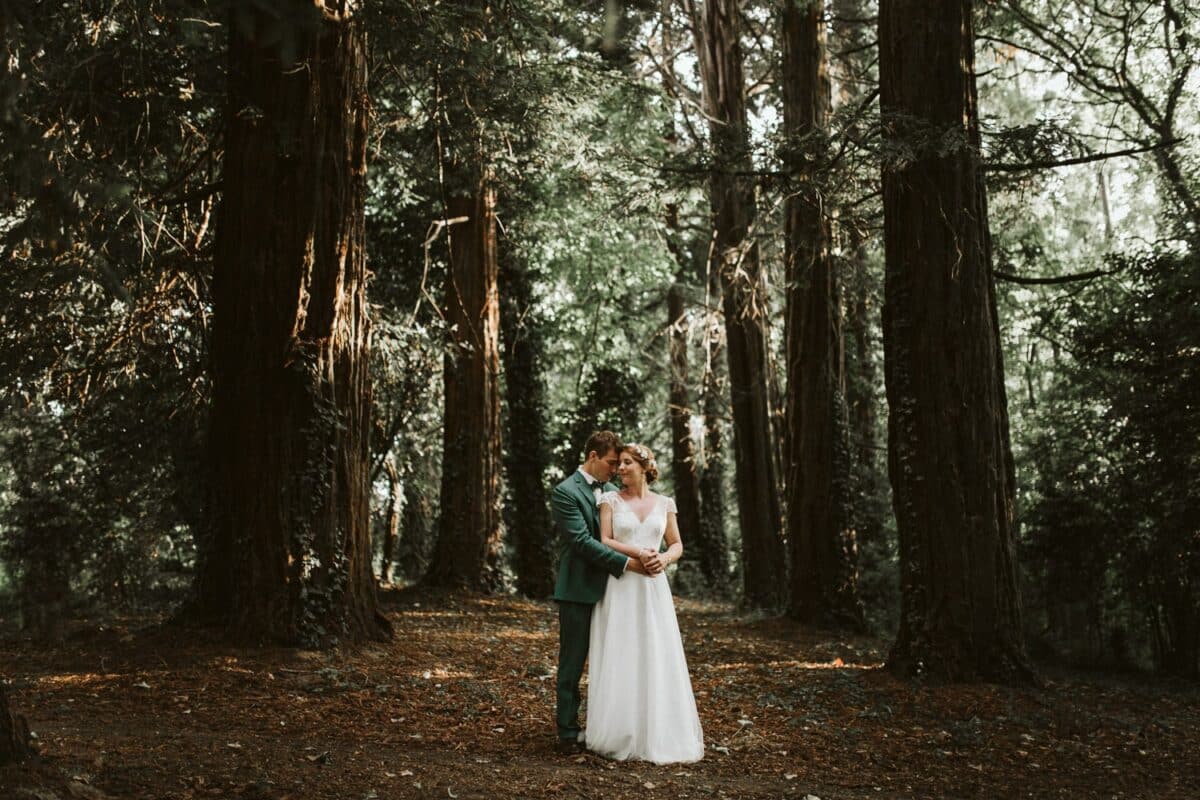 Séance couple en forêt, lumière dorée, grands arbres du parc du Château de la Pigossière.