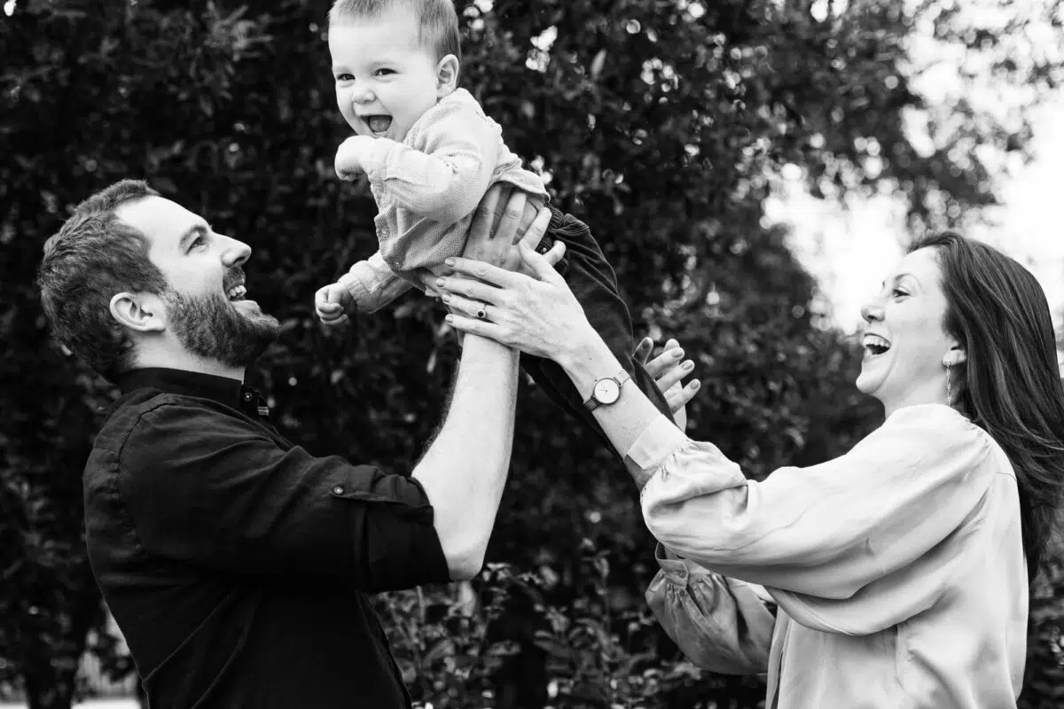 couple qui porte leur enfant en jouant
