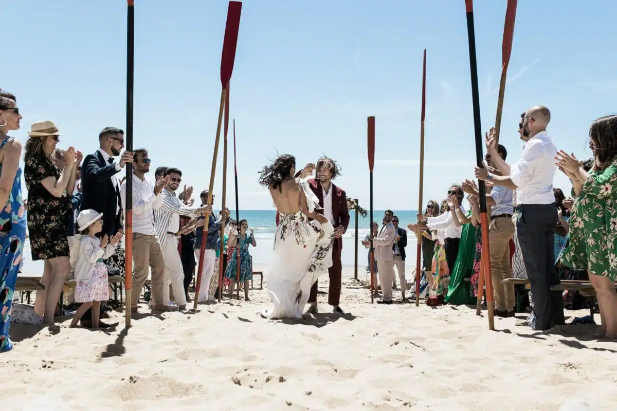 Garde d’honneur à la rame sur la plage, les mariés avancent en riant — mariage à Saint-Jean-de-Monts, Vendée