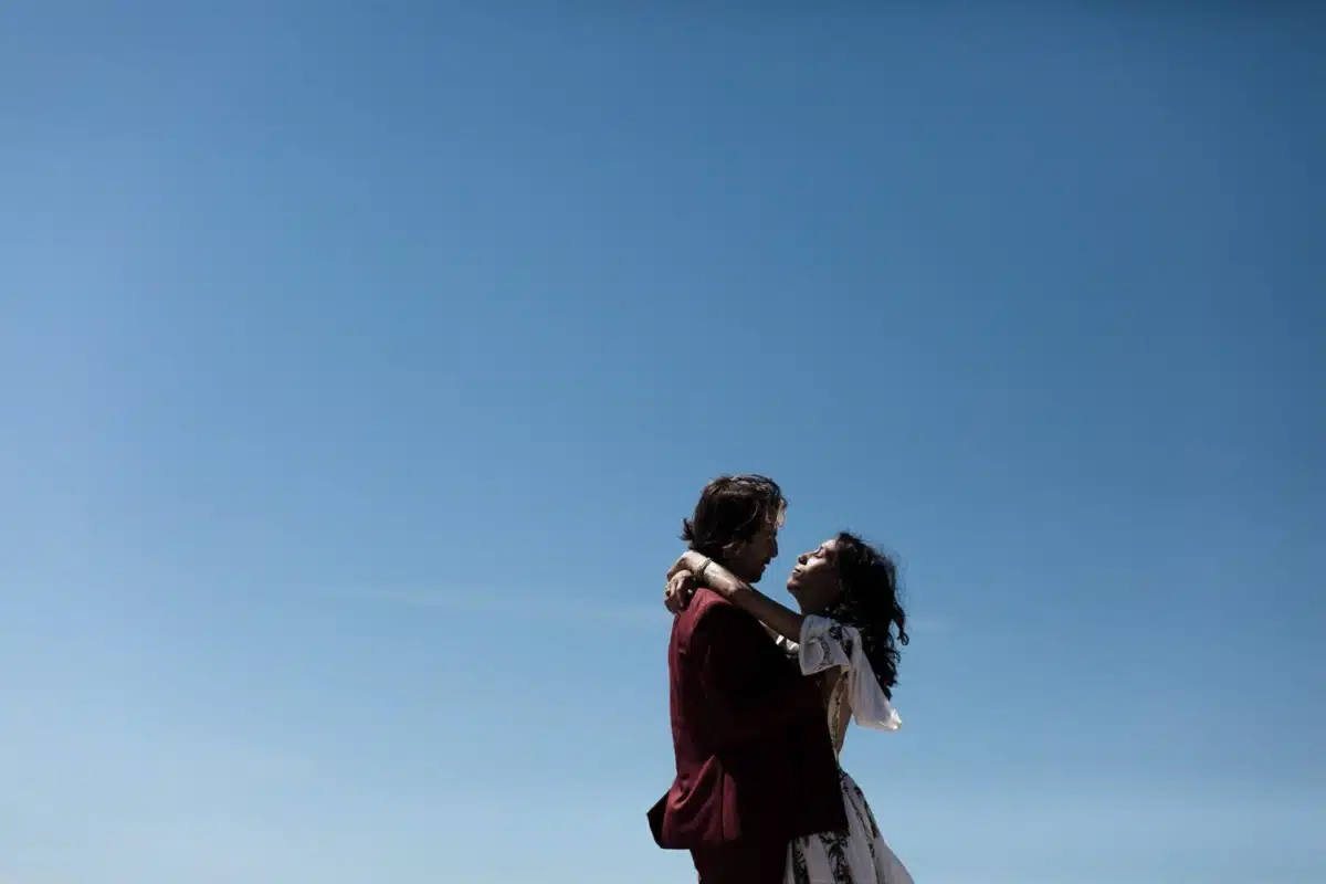 Les mariés s’enlacent sous un ciel bleu immense — mariage sur la plage en Vendée.