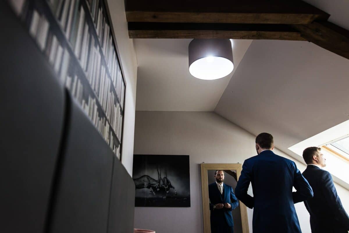 Préparatifs du marié, ajustement du costume devant le miroir avec ses témoins.