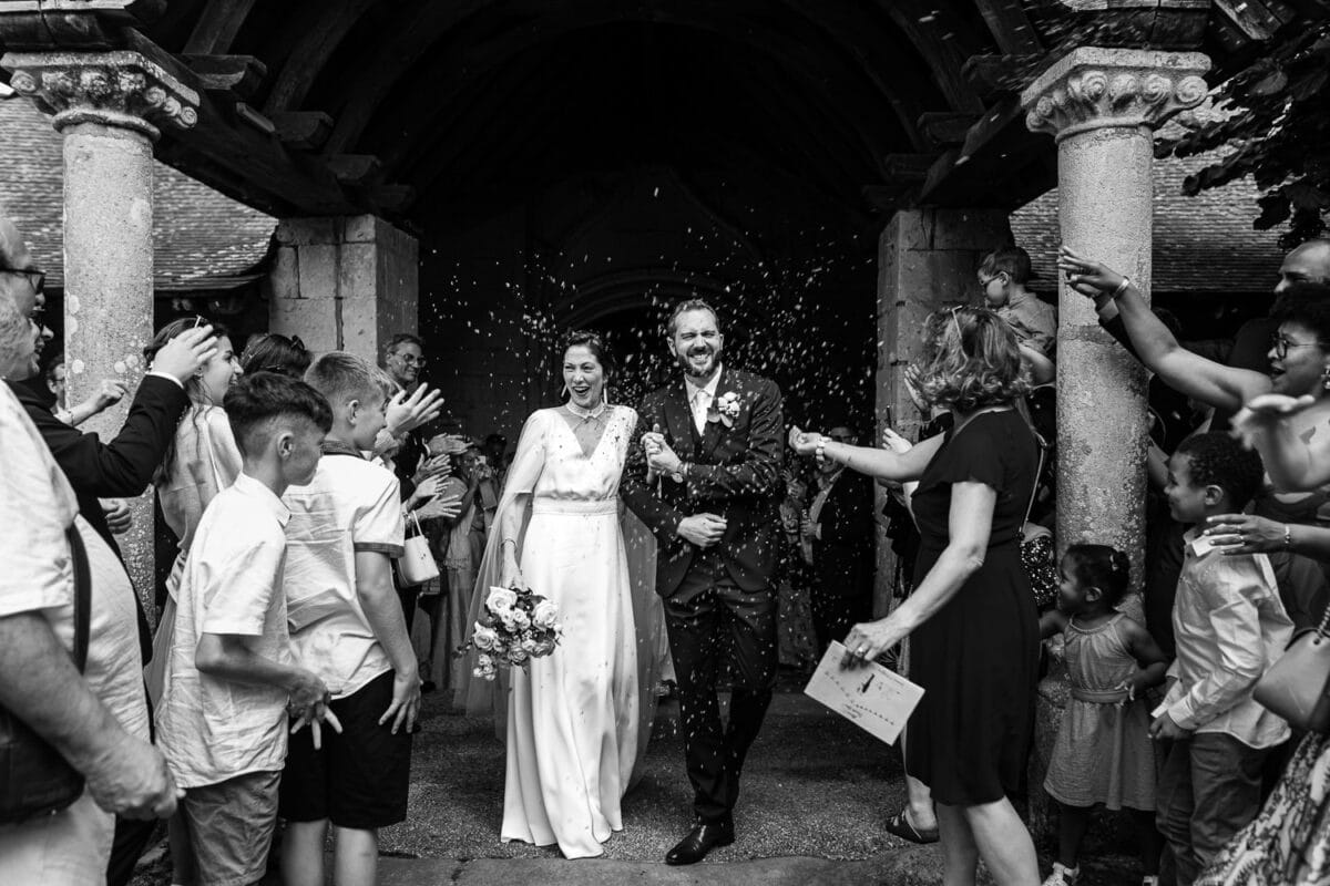 Sortie d’église des mariés sous les confettis, haie d’honneur des invités.