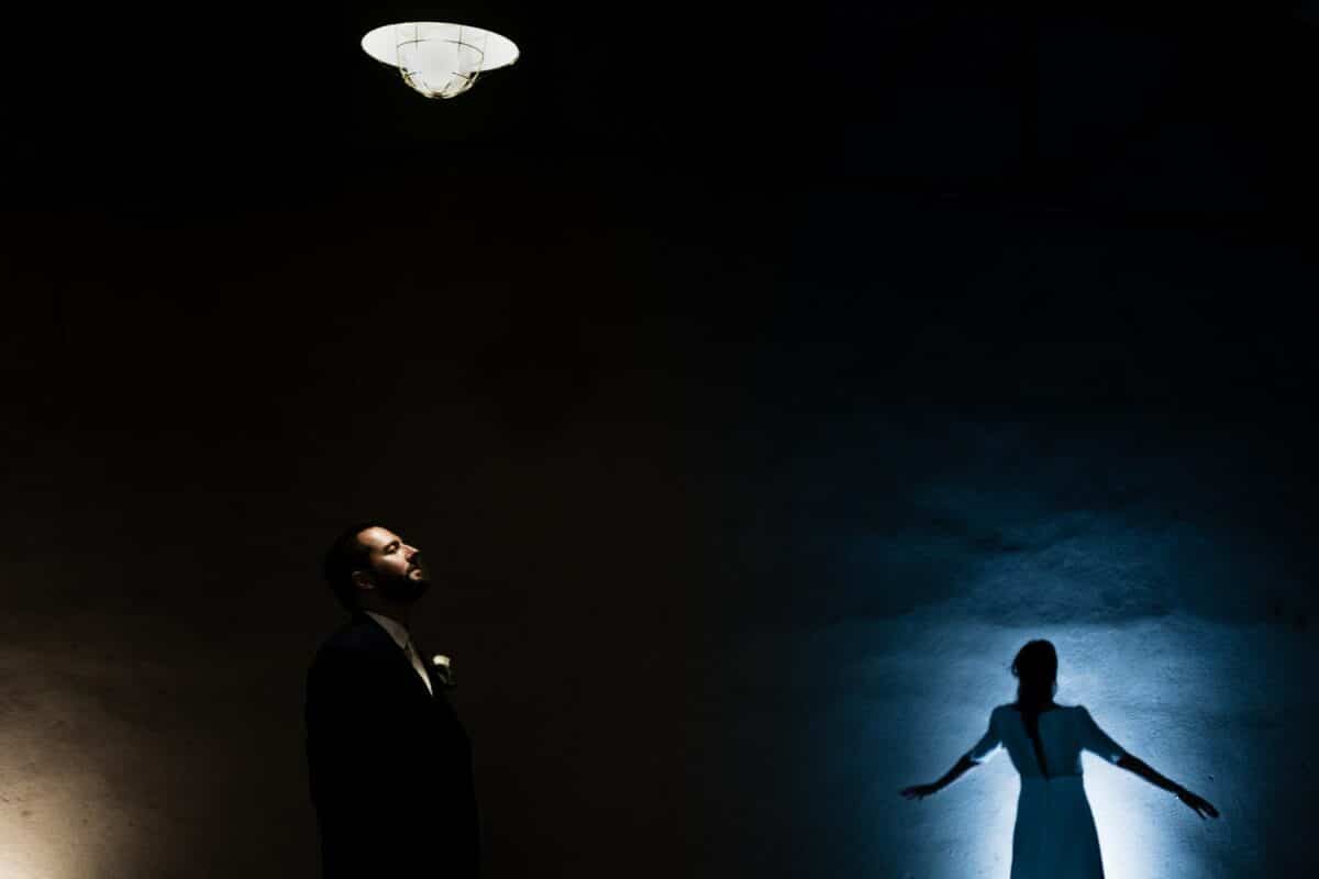 Portrait créatif des mariés, lumière dramatique et silhouette bleutée – Manoir de la Jahotière.
