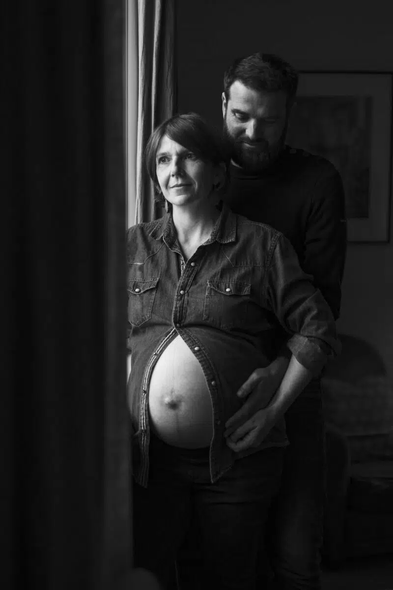 femme enceinte a la fenetre et homme derrière