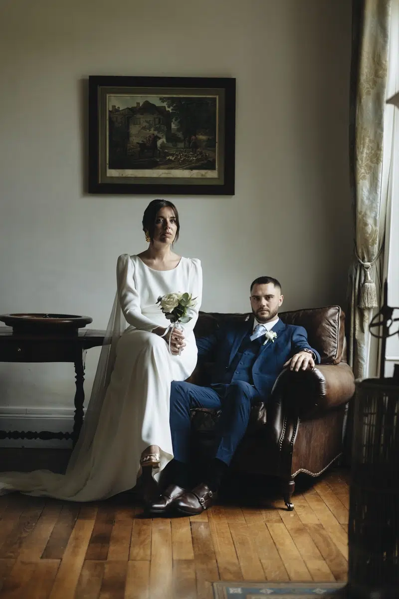 portrait couple assis sur un fauteuil en cuir près d'une fenetre