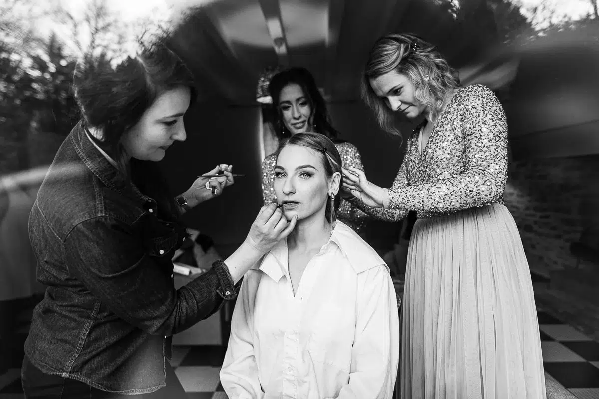 Préparation de la mariée lors d’un mariage, maquillage et coiffure entourée de ses proches – photographe de mariage.