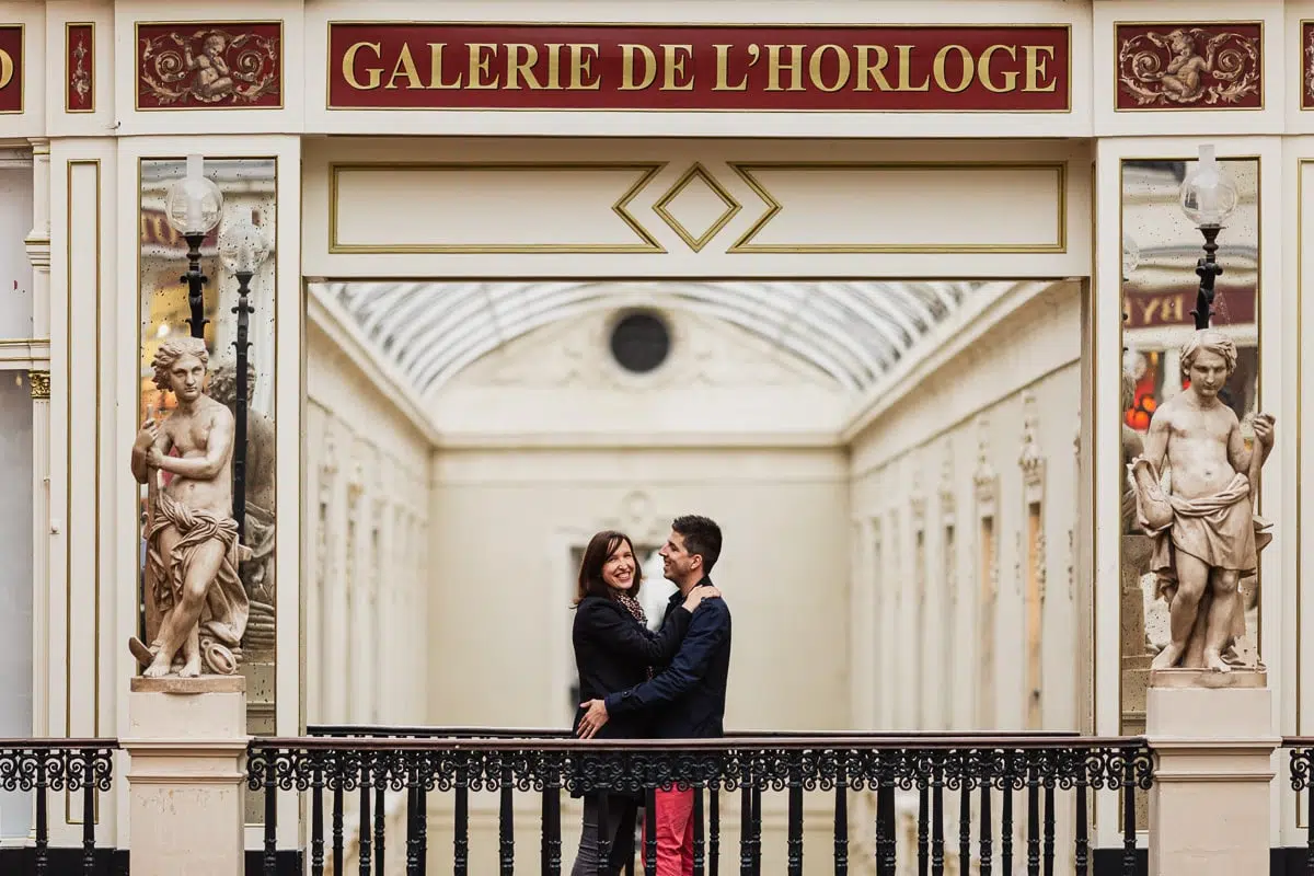 couple posant devant une main courante au passage pommeraye a nantes devant des statues
