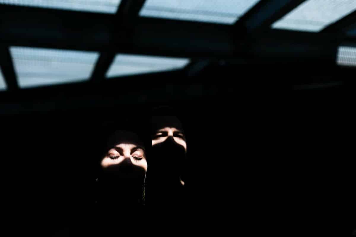 Jeux d’ombres sous verrière : faisceau lumineux sur les yeux fermés.