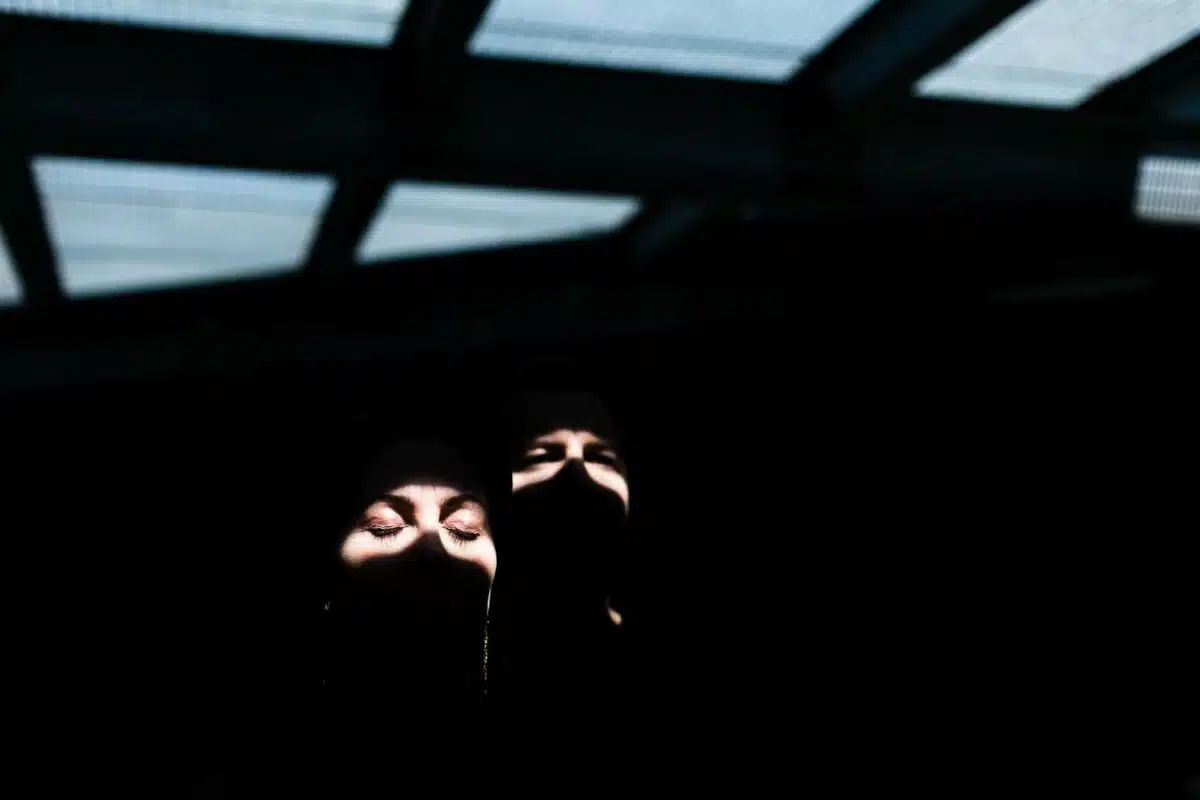 Jeux d’ombres sous verrière : faisceau lumineux sur les yeux fermés.
