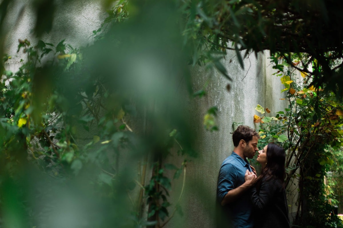 Couple s’enlaçant dans une ruelle verdoyante de Trentemoult à Nantes, lors d’une séance photo romantique et naturelle.