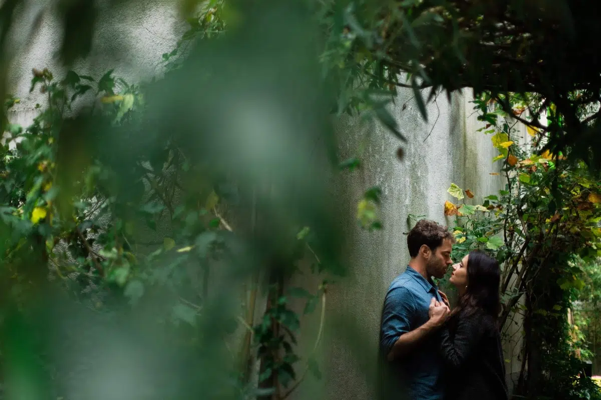 Couple s’enlaçant dans une ruelle verdoyante de Trentemoult à Nantes, lors d’une séance photo romantique et naturelle.