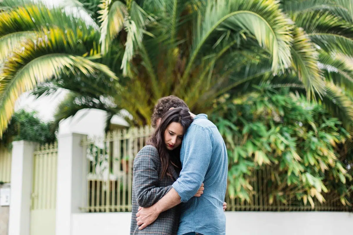 couple posant durant la séance engagement devant un palmier a trentemoult près de Nantes