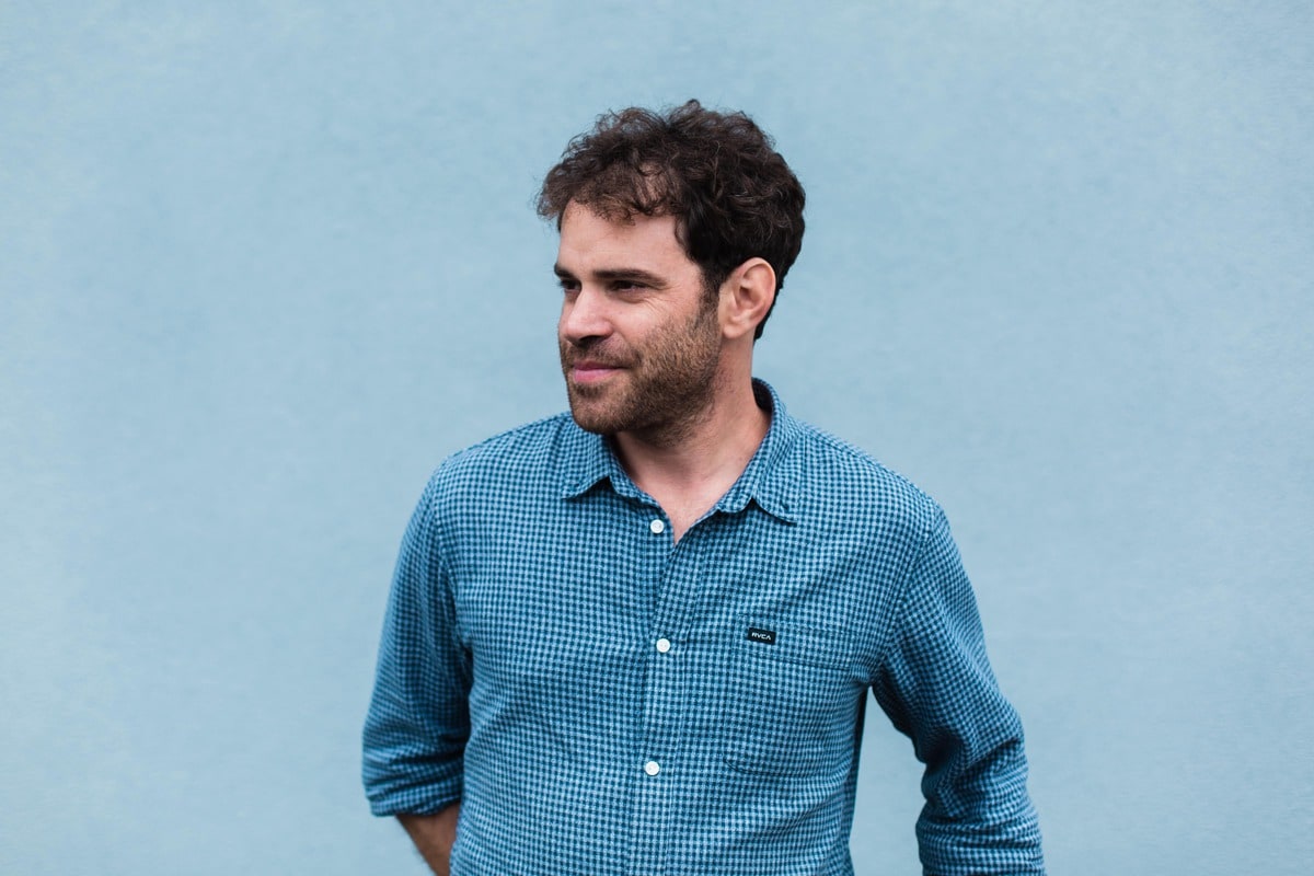 portrait d'un homme enchemise devant un mur bleu