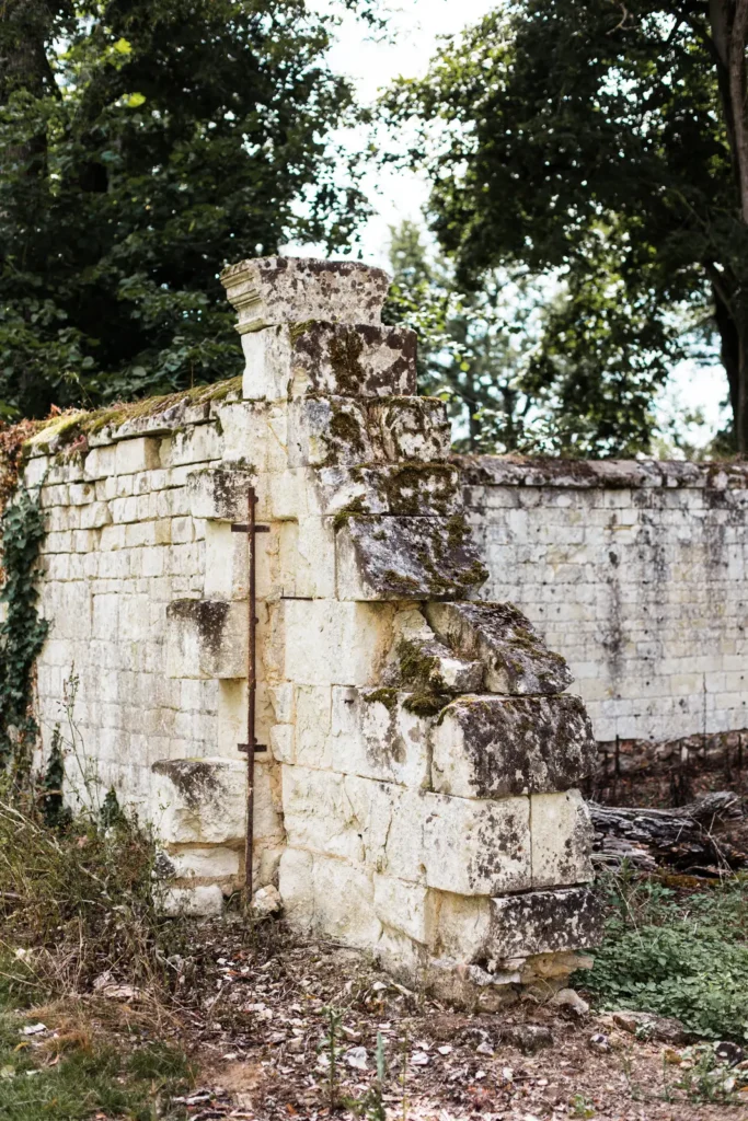 Détail d'un mur ancien en ruine et muret de pierre moussue au Domaine de Roiffé, décor de mariage authentique.
