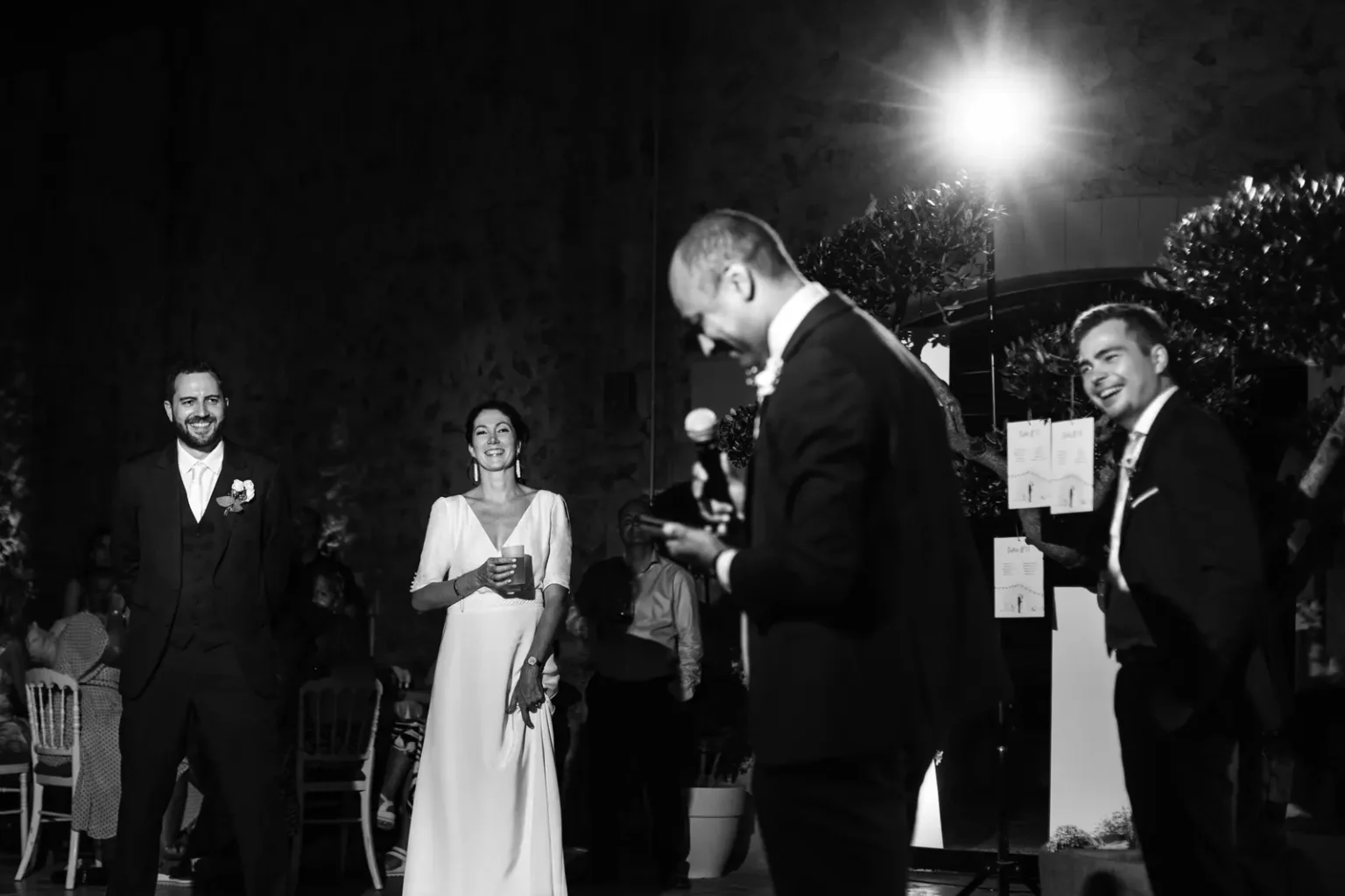 Discours de mariage lors de la réception au Domaine de Roiffé, mariés souriants en arrière-plan sous un éclairage de soirée.