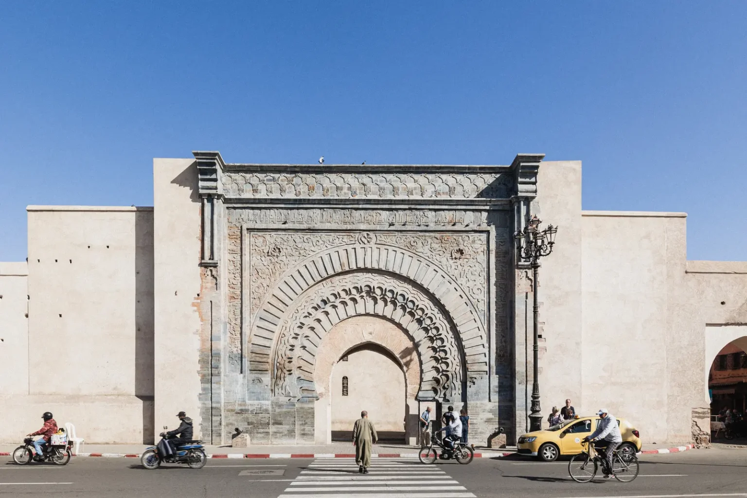 Vue de la porte historique Bab Agnaou à Marrakech sous un ciel bleu, architecture traditionnelle marocaine.