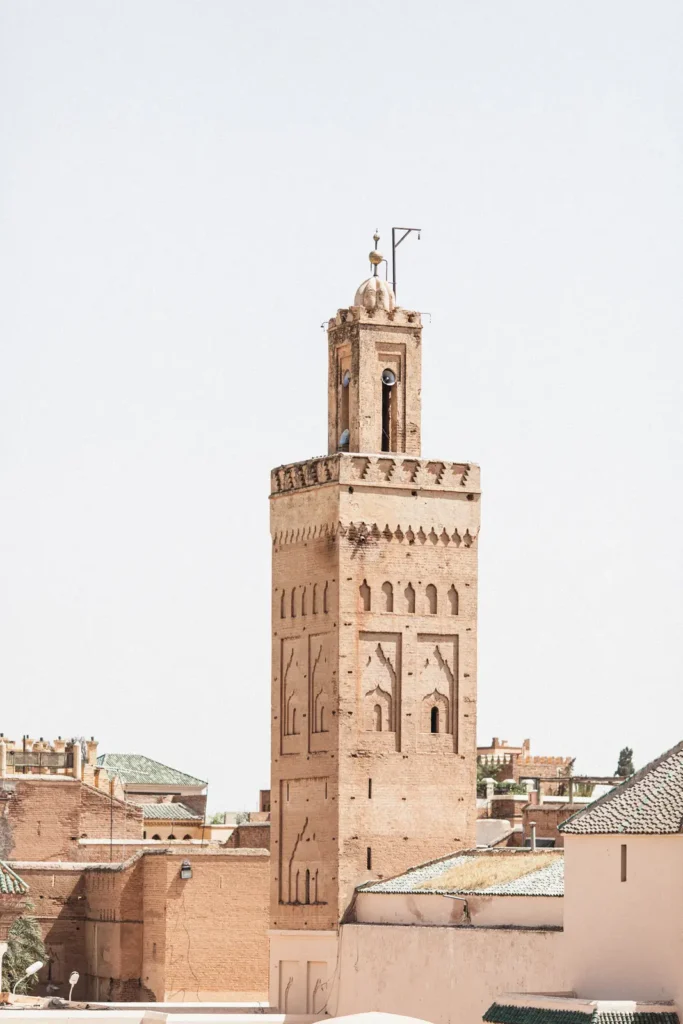 Vue sur un minaret de Marrakech dominant les toits de la médina, photographie d'architecture au Maroc.