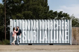 couple devant un container avec ecrit on va marcher sur la lune aux machines de l'ile à Nantes