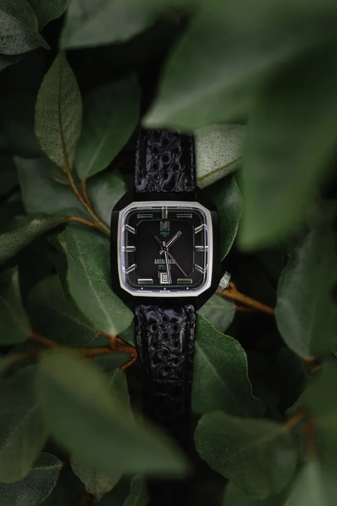 Gros plan d'une montre de luxe dans des feuillages verts. Style minimaliste et créatif