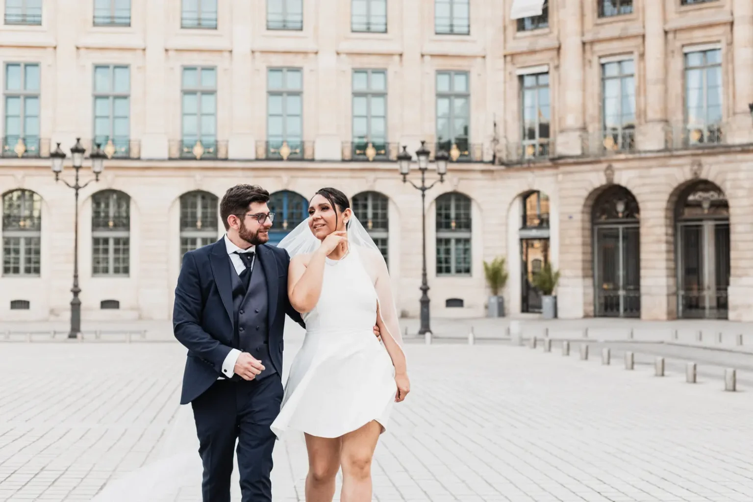 Diana et Jean-Baptiste qui marchent place Vendôme le jour de leur mariage à Paris